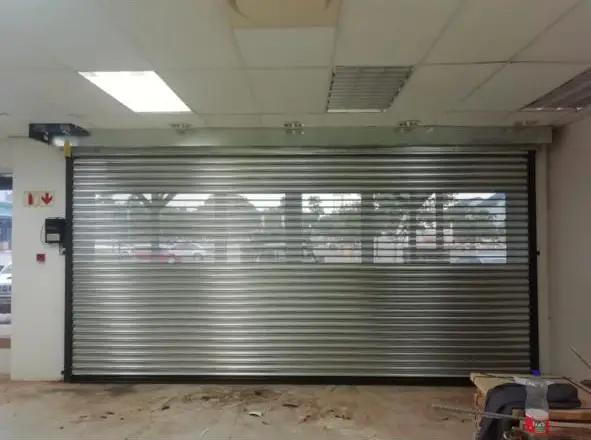 Galvanized roller shutter door closing a shopfront, seen from inside