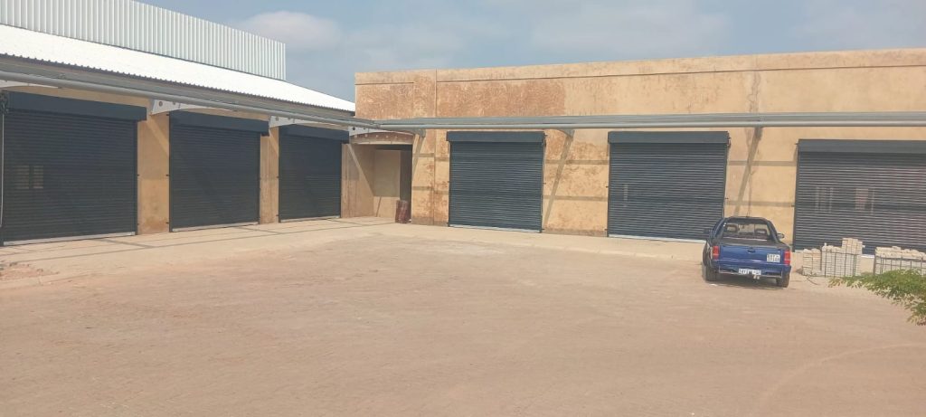 Row of dark roller shutter doors on an industrial storage building